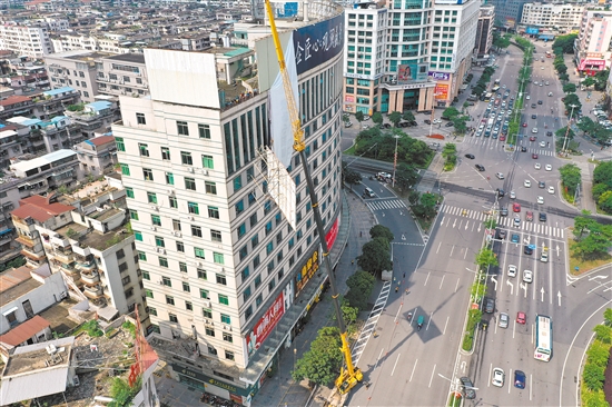 由于要拆除的廣告牌在樓頂，工作人員動用75米高的吊機進行作業(yè)。