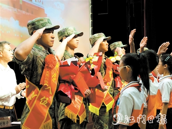 小學(xué)生代表向入伍新兵代表獻(xiàn)上鮮花。