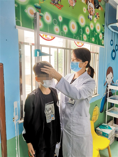 醫(yī)生為兒童量身高。