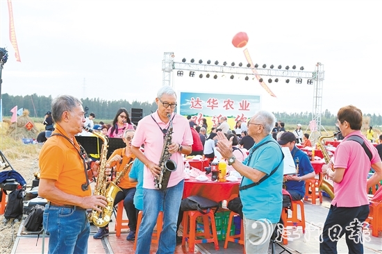 表演人員在稻田里吹響薩克斯風(fēng)，與澳門禮樂鄉(xiāng)親齊慶豐收。