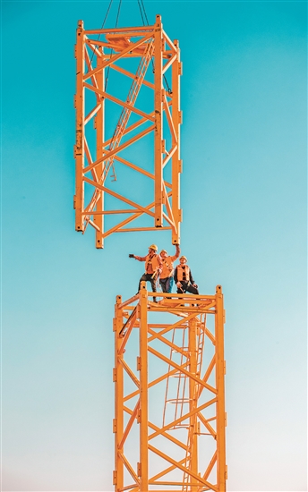 建設(shè)者小小身軀“指揮”大型鋼構(gòu)件。