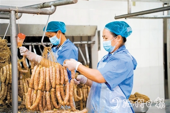 工人們正在制作禮樂臘味。邱昱