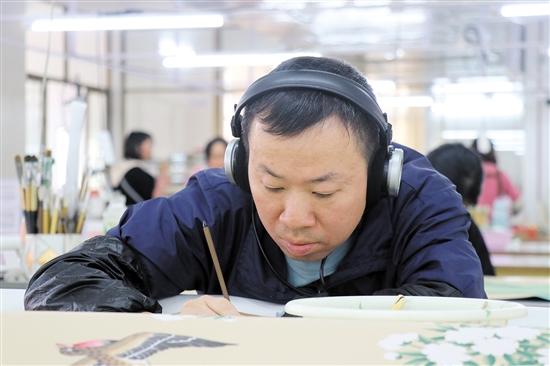 畫師戴著耳機(jī)，可以讓精神更專注。（受訪者供圖）