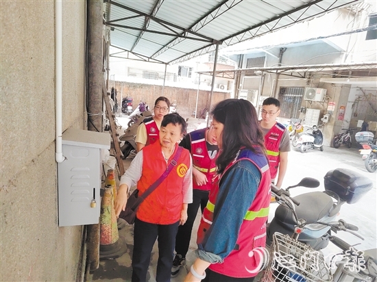 退休黨員干部鄧玉歡與網(wǎng)格員一起就充電樁選址開(kāi)展調(diào)研。