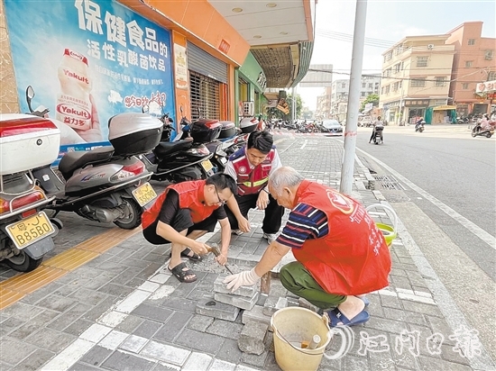 網(wǎng)格員和志愿者一同修復(fù)路面。