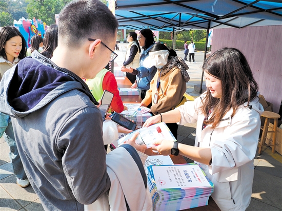 工作人員為捐贈步數(shù)的參加者頒發(fā)公益證書。