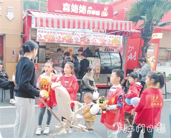 統(tǒng)一身著志愿者服裝的孩子們化身“愛心小掌柜”，向顧客推銷商品。