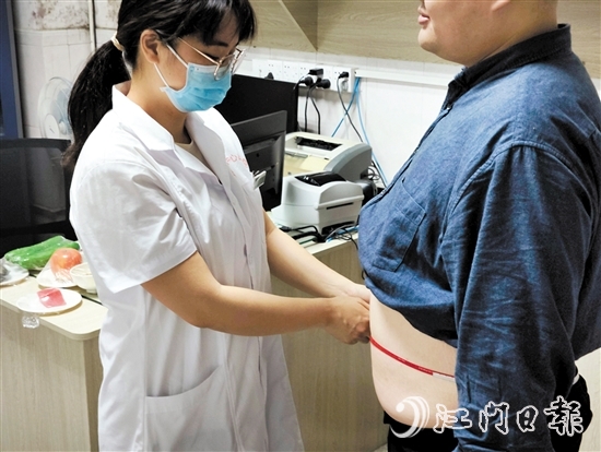 醫(yī)生為記者測(cè)量腰圍。