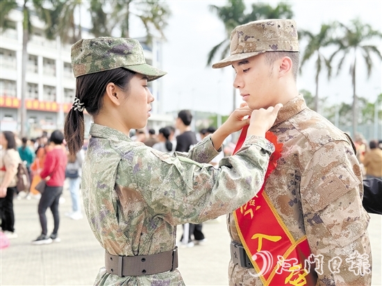 在歡送儀式現(xiàn)場，老兵姐姐為新兵弟弟整理軍裝。