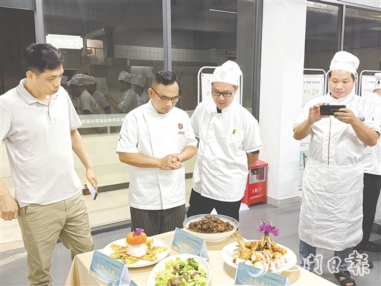 伍立更（左二）對(duì)學(xué)員們的自創(chuàng)菜式一一進(jìn)行點(diǎn)評(píng)和指導(dǎo)。