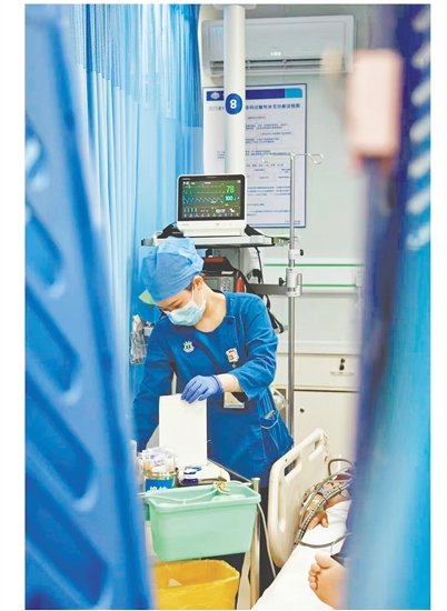 這是一雙爭分奪秒的手。急診搶救室是與時(shí)間賽跑的“生命戰(zhàn)場”，收治的都是急危重癥患者，生死往往就在一瞬間。面對心梗病人，江門市中心醫(yī)院急診科護(hù)士譚秀娟正專心致志地為患者做心電圖檢查，用專業(yè)與仁心守護(hù)生命之光。