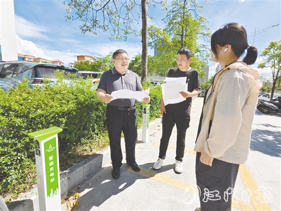 余中宏（左一）與同事一起查看“民生服務(wù)充電站”項目建設(shè)進(jìn)度。