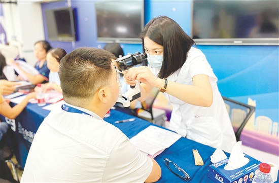 醫(yī)護(hù)人員為企業(yè)職工檢查眼睛。