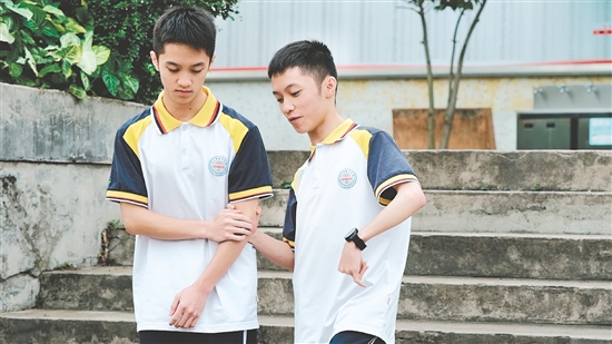 校園里，弟弟（左）和哥哥（右）相互扶持。
