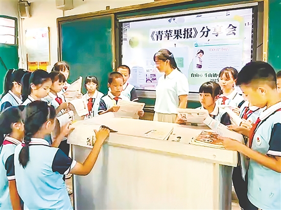 老師與同學們一起賞析《青蘋果》上刊登的優(yōu)秀作文。