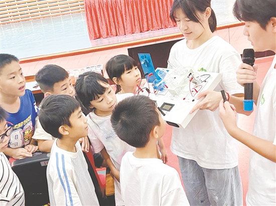 服務隊隊員向孩子們展示氫燃料電池演示儀。