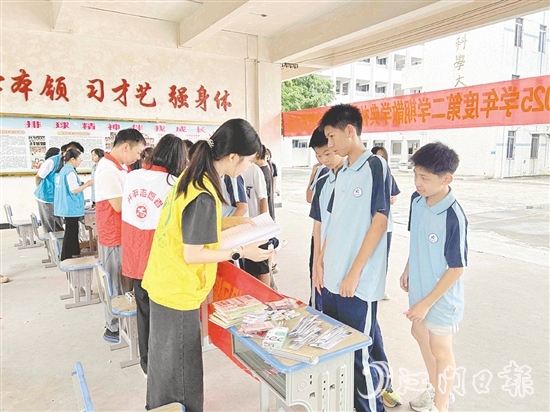 工作人員向?qū)W生宣傳防溺水知識(shí)。