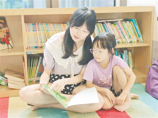 在龍溪湖閱讀中心，一位家長正陪伴孩子讀繪本。