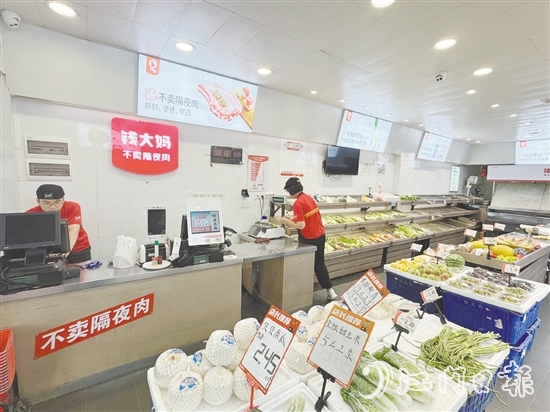 錢大媽生鮮店的工作人員正在線上接單并準(zhǔn)備菜品。