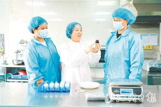 在培訓(xùn)室里，梁艷芬（中間白衣）和大家交流蛋品檢測方式。