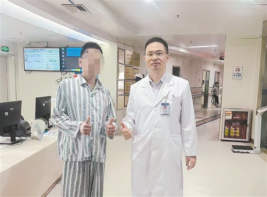 患者和醫(yī)生合影，豎起大拇指表示肯定。