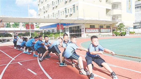 參賽隊(duì)員們緊握長(zhǎng)繩，齊心協(xié)力，鼓足勁拼命往后拉。