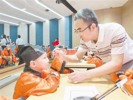 在朱砂啟智環(huán)節(jié)，教師用毛筆在新生的額頭點(diǎn)上紅痣。