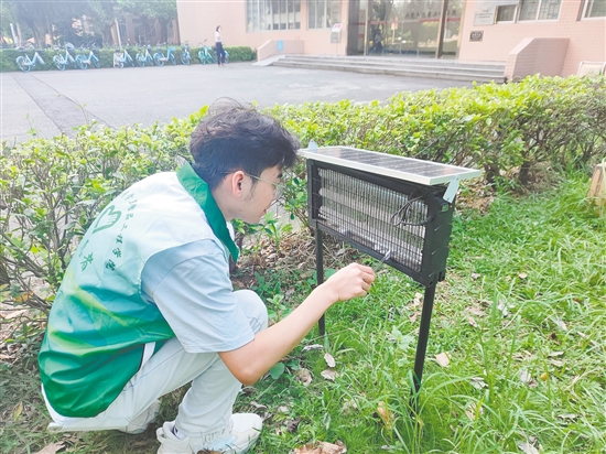 五邑大學(xué)志愿者在戶外投放人體氣味仿生蚊蟲誘捕劑。