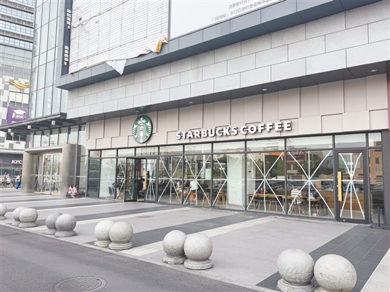 我市商戶、市民用各種小技巧加固玻璃幕墻。圖為開(kāi)平東匯城部分商戶貼“米”字膠帶防風(fēng)。