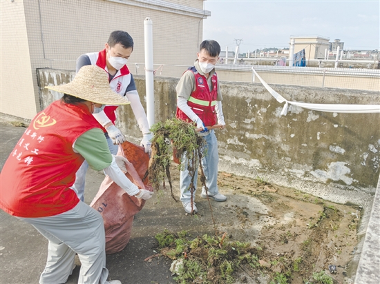 廣大黨員干部當(dāng)先鋒，圖為鶴山市桃源鎮(zhèn)黨員干部正在清理天臺(tái)垃圾。