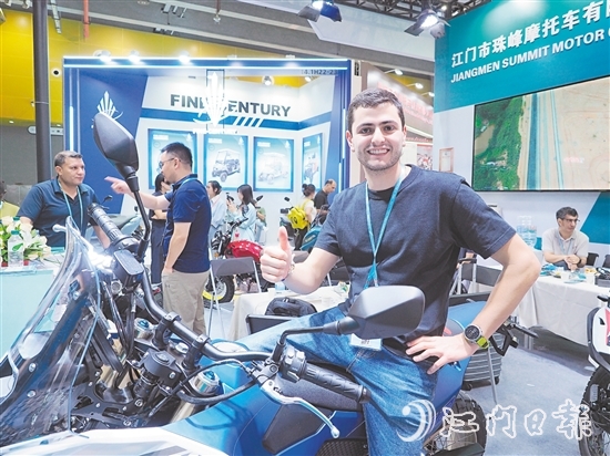 在江門市珠峰摩托車有限公司展位，外國客商前來了解摩托車新品情況，并為產(chǎn)品點(diǎn)贊。張澤彬