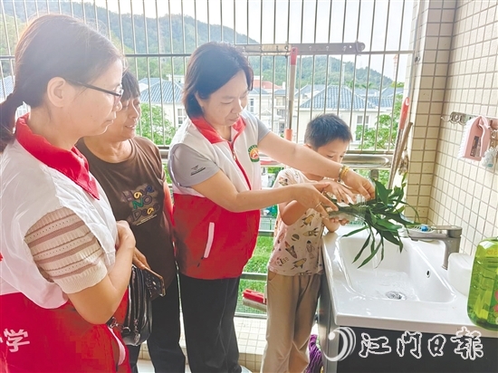 恩平市鰲峰小學(xué)黨員教師入戶指導(dǎo)學(xué)生清積水。