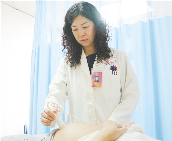 產(chǎn)科醫(yī)生為孕婦檢查胎兒狀況。