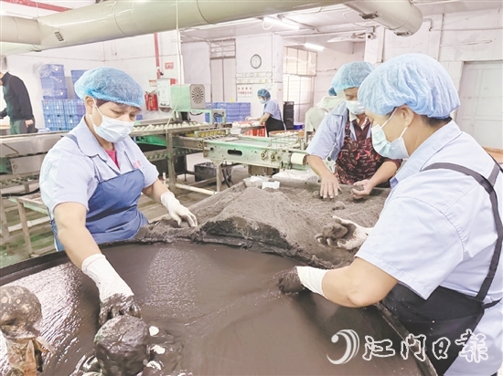 工作人員將裹稻草灰漿的咸蛋放到干稻草灰滾動(dòng)一下，就完成咸蛋包裹工藝。