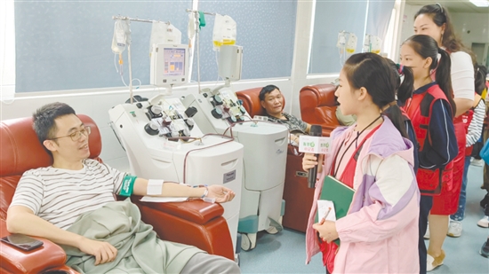 小記者采訪正在獻(xiàn)血的志愿者。