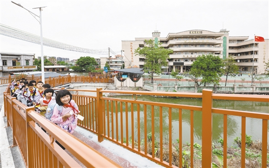 雙橋小學(xué)的學(xué)生放學(xué)后在新修建的步道上結(jié)伴而行，身旁的車流被欄桿有效隔離，構(gòu)筑起校園交通的安全防線。