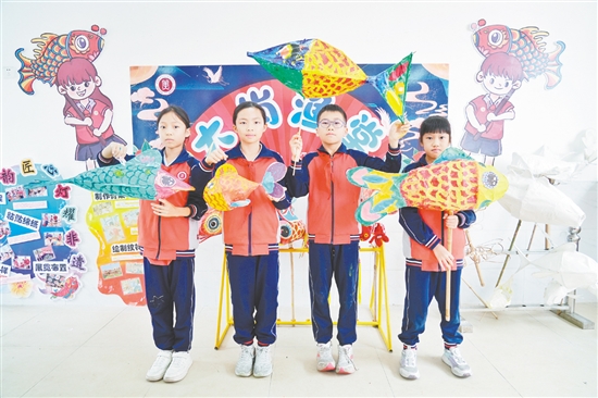 雅瑤鎮(zhèn)大崗小學學生展示制作好的魚燈作品。