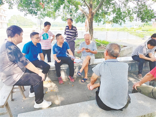 關(guān)文勇（中）在基層一線聽取了解民意。