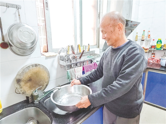 榕樹村村民麥成建在廚房用干凈的自來水清洗餐具。