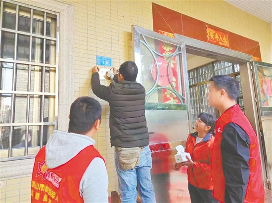 服務(wù)站工作人員細(xì)心地將“光榮之家”牌匾安裝到位。