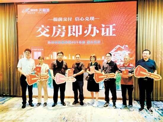 業(yè)主喜拿房產(chǎn)證和鑰匙。