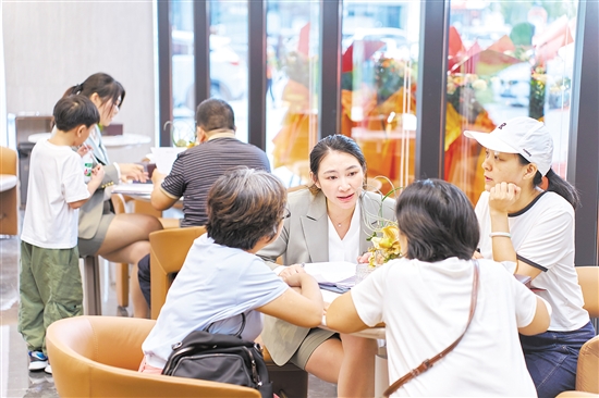 今年國慶假期，全市主要房地產(chǎn)項目認購近2300套,圖為銷售人員在接待客人。