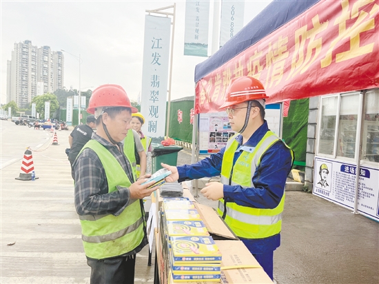 工地施工人員排隊領取防蚊用品。